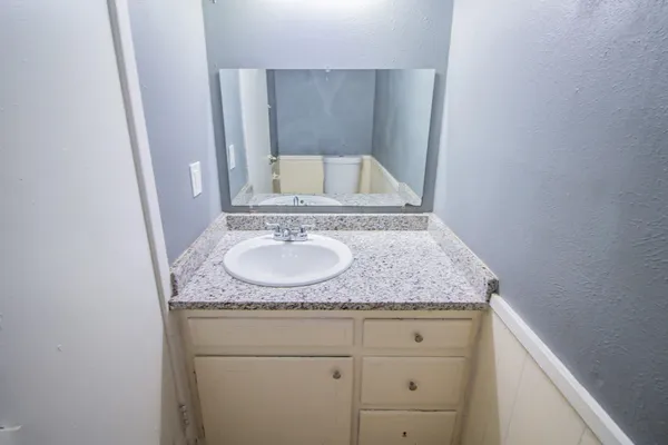 a bathroom with a granite countertop sink and a mirror