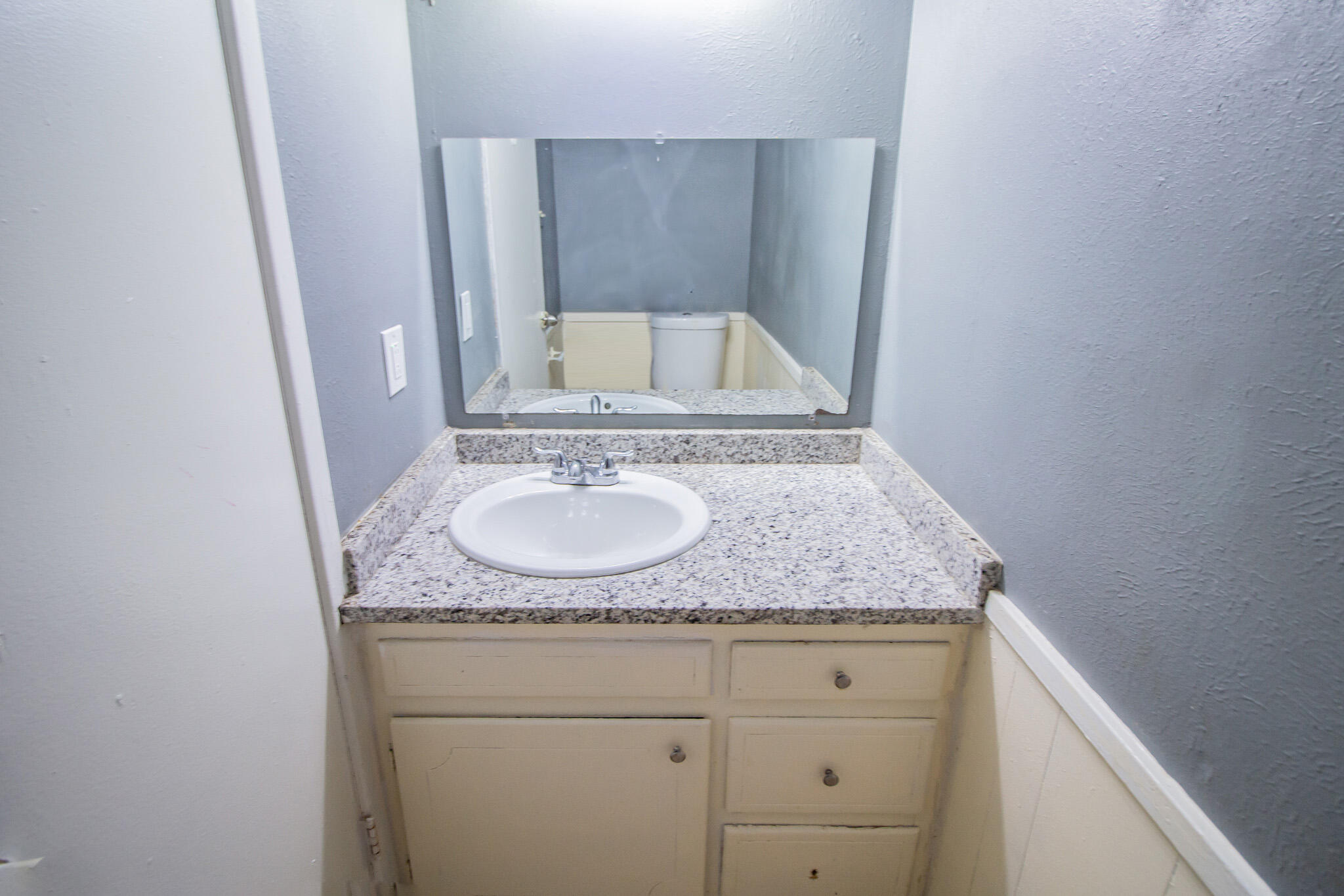 2101 49th Street Lubbock, TX 79412 - Photo 29 of 31 a bathroom with a granite countertop sink and a mirror
