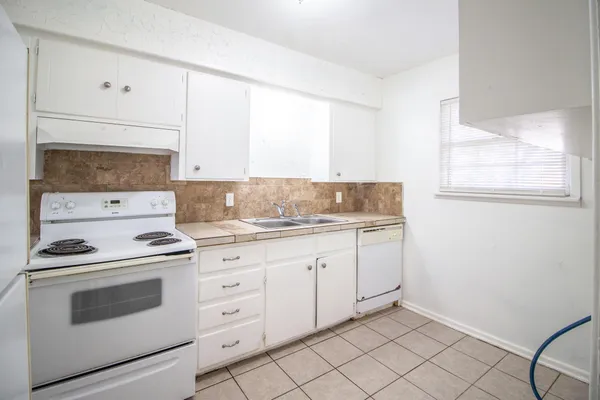 a kitchen with granite countertop white cabinets and white appliances