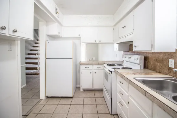 a kitchen with a stove a refrigerator and a sink