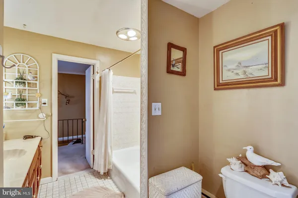 a view of a hallway with bathroom and wooden floor