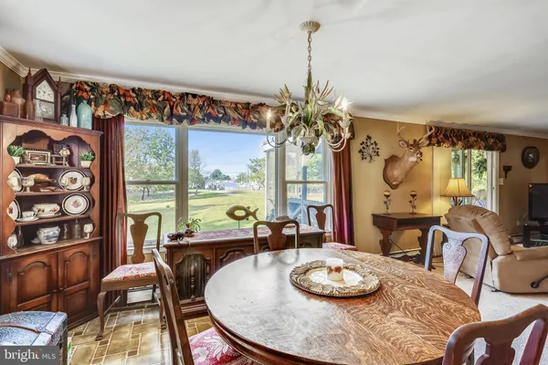 a dining room with furniture and a large window