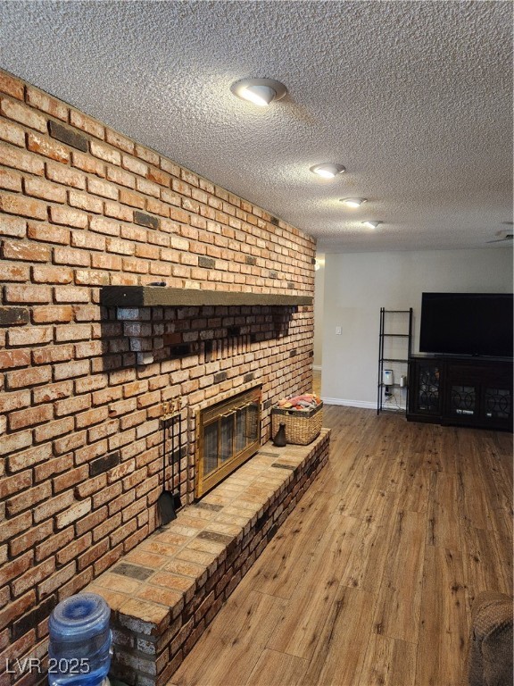 2645 South Lindell Road Las Vegas, NV 89146 - Photo 12 of 30 Unfurnished living room featuring a fireplace, hardwood / wood-style floors, and a textured ceiling