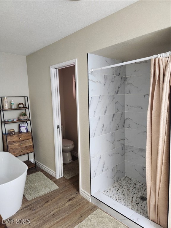 2645 South Lindell Road Las Vegas, NV 89146 - Photo 18 of 30 Bathroom featuring a stall shower, wood finished floors, and a freestanding bath