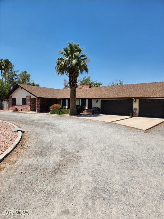 2645 South Lindell Road Las Vegas, NV 89146 - Photo 3 of 30 Ranch-style house featuring a 3 car garage, concrete driveway, and brick siding