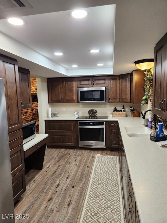 2645 South Lindell Road Las Vegas, NV 89146 - Photo 7 of 30 Kitchen featuring wall oven, light wood-style floors, dark brown cabinetry, light countertops, and stovetop
