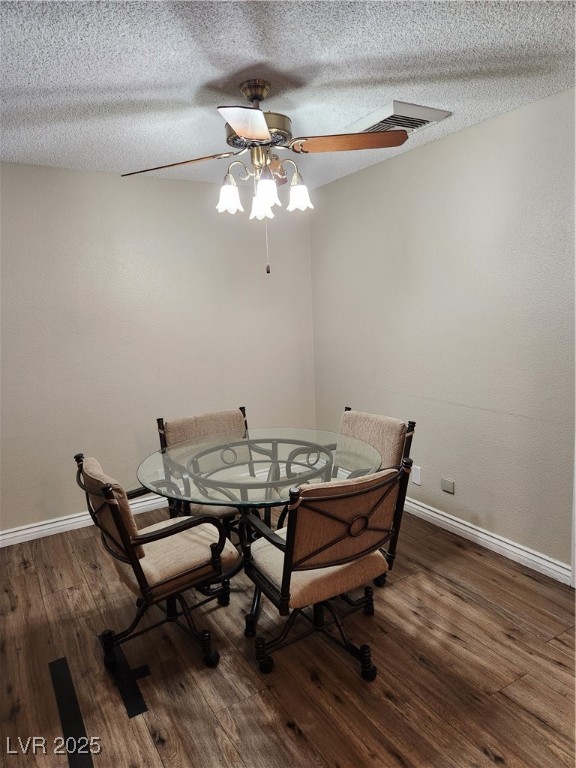 2645 South Lindell Road Las Vegas, NV 89146 - Photo 9 of 30 Dining room with a ceiling fan, dark wood-type flooring, and a textured ceiling