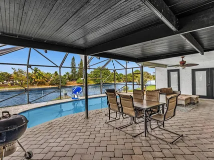 a patio with glass top table and chairs