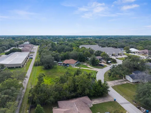 an aerial view of residential houses with outdoor space and trees