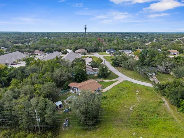 an aerial view of a house with a yard and lake