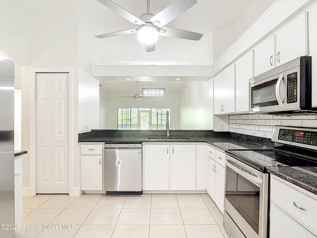 a kitchen with granite countertop white cabinets a sink and dishwasher