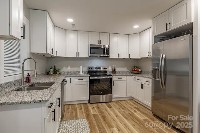 a kitchen with stainless steel appliances granite countertop a refrigerator sink and stove