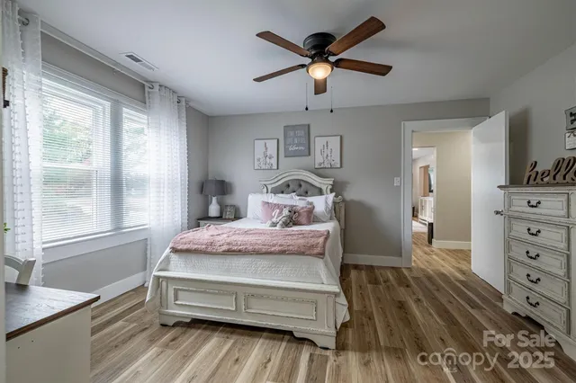 a spacious bedroom with a bed a window and a chandelier