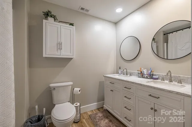 a bathroom with a toilet a sink a mirror and a window