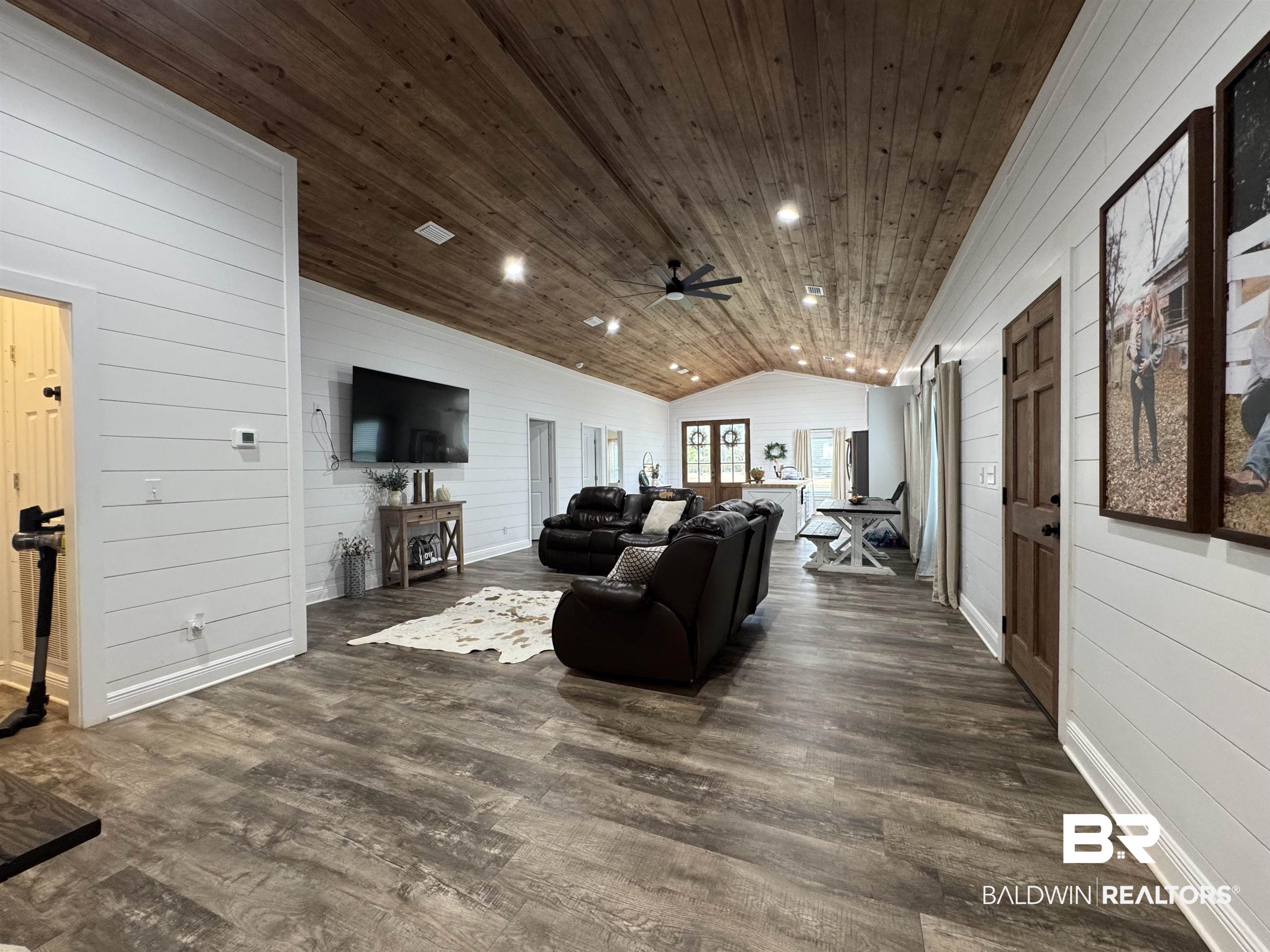 370 Dianne Road Frisco City, AL 36445 - Photo 30 of 41 Living room with lofted ceiling, wooden walls, wooden ceiling, dark hardwood / wood-style floors, and ceiling fan