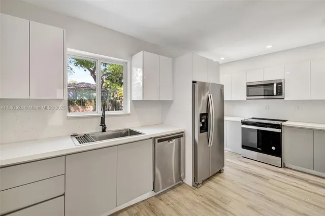 a kitchen with a sink a refrigerator and window