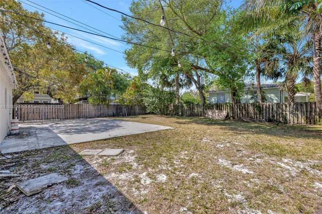 a view of a yard with wooden fence