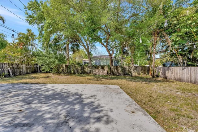 a view of yard with swimming pool and wooden fence