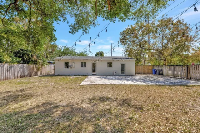 a view of a house with backyard and tree