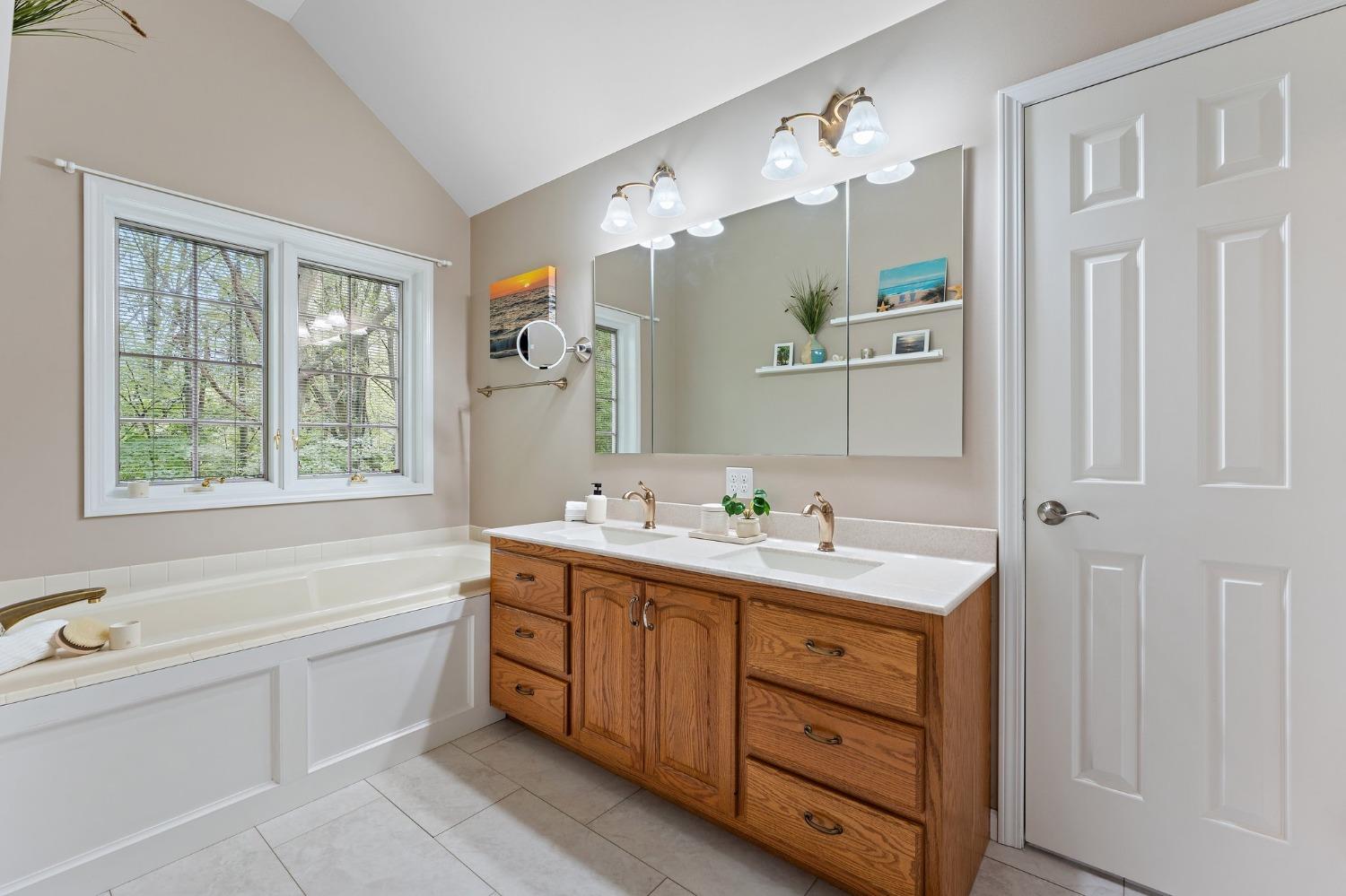 5964 West Schultz Road La Porte, IN 46350 - Photo 35 of 53 a spacious bathroom with a double vanity sink a large mirror a bathtub and window