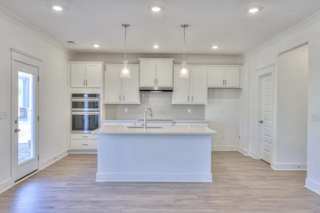 an empty room with wooden floor fireplace and windows