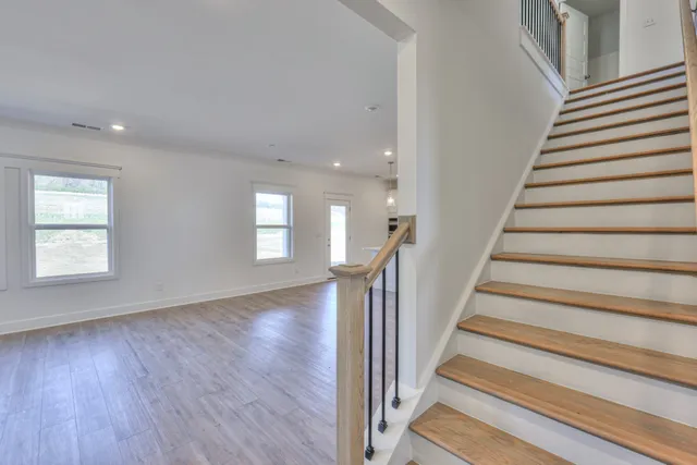 a view of a hallway with wooden floor and entryway