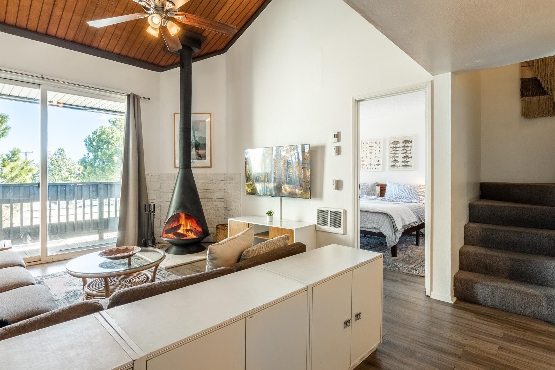 137 Laurel Mountain Road, Unit 227 Mammoth Lakes, CA 93546 - Photo 12 of 28 Living area featuring a wood stove, wooden ceiling, dark wood-style floors, and ceiling fan