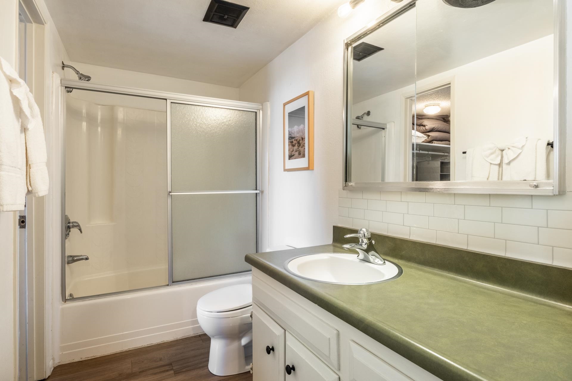 137 Laurel Mountain Road, Unit 227 Mammoth Lakes, CA 93546 - Photo 14 of 28 Bathroom featuring vanity, decorative backsplash, shower / bath combination with glass door, and dark wood-style floors