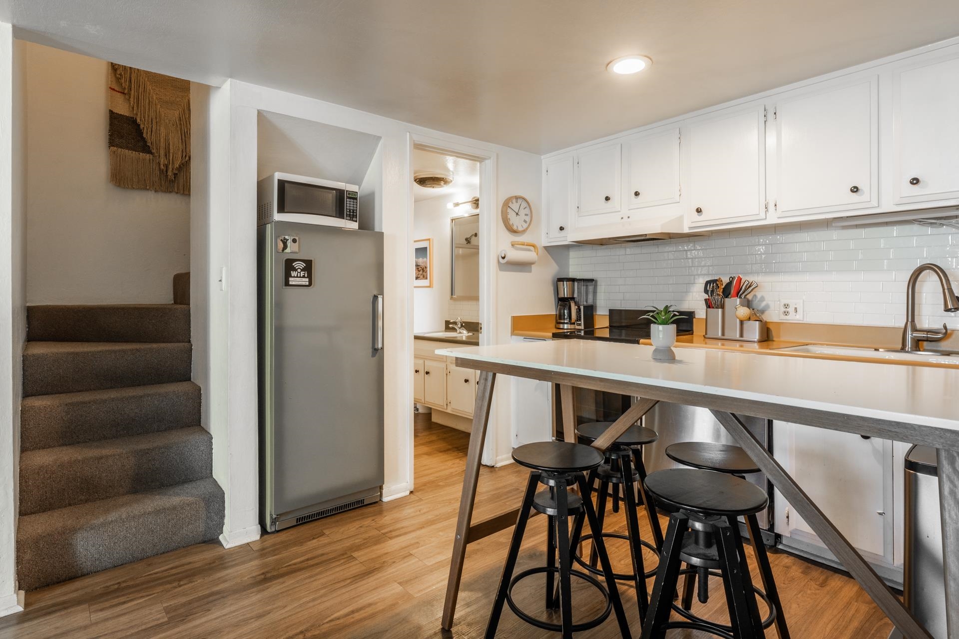 137 Laurel Mountain Road, Unit 227 Mammoth Lakes, CA 93546 - Photo 7 of 28 Kitchen with freestanding refrigerator, white cabinets, light wood-type flooring, and tasteful backsplash