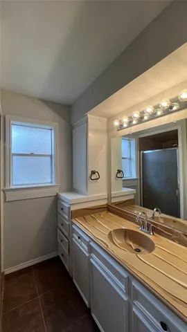 a bathroom with a granite countertop sink and a large mirror
