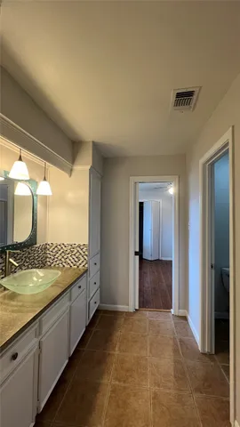 a bathroom with a granite countertop sink and a mirror