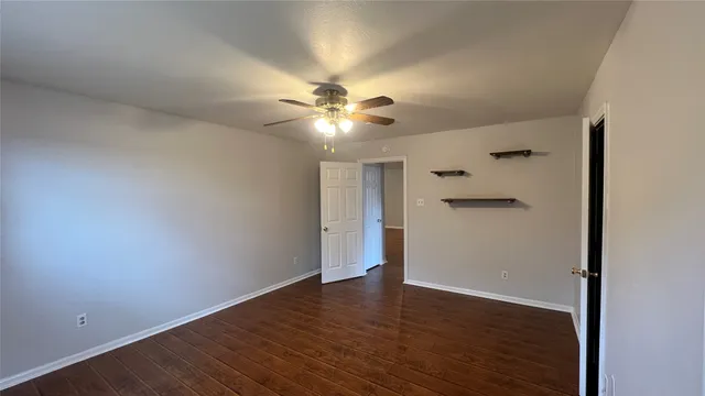 an empty room with a window and a fan