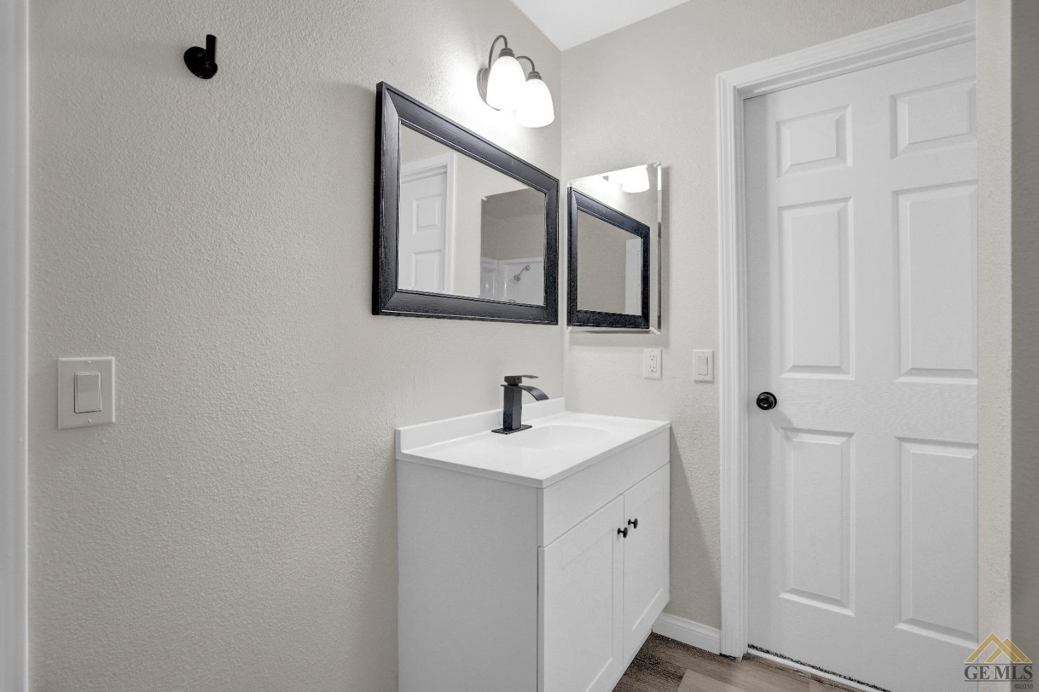 Undisclosed Address Bakersfield, CA 93304 - Photo 15 of 32 a bathroom with a sink vanity and a mirror