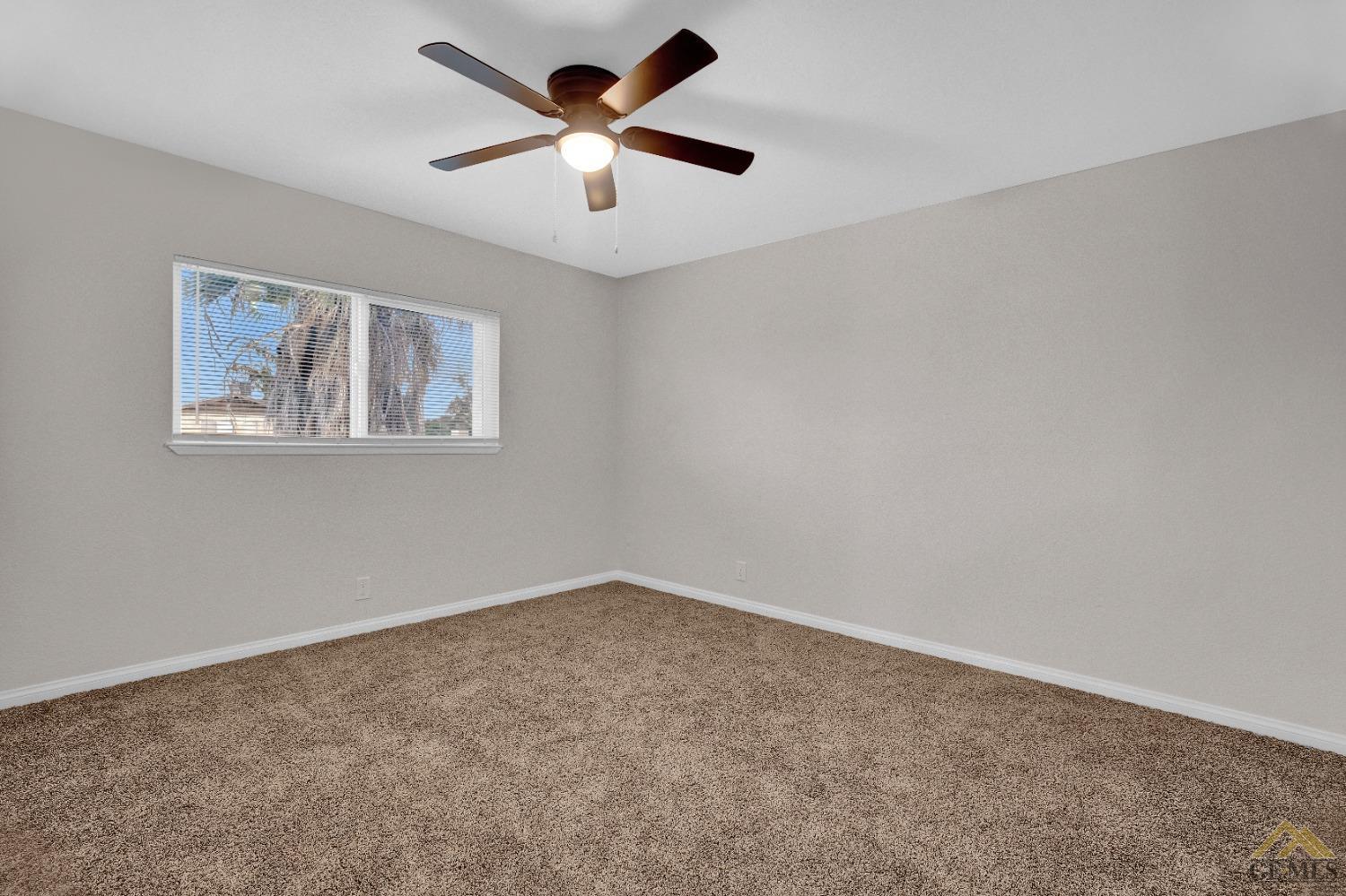 Undisclosed Address Bakersfield, CA 93304 - Photo 21 of 32 an empty room with a window and a fan