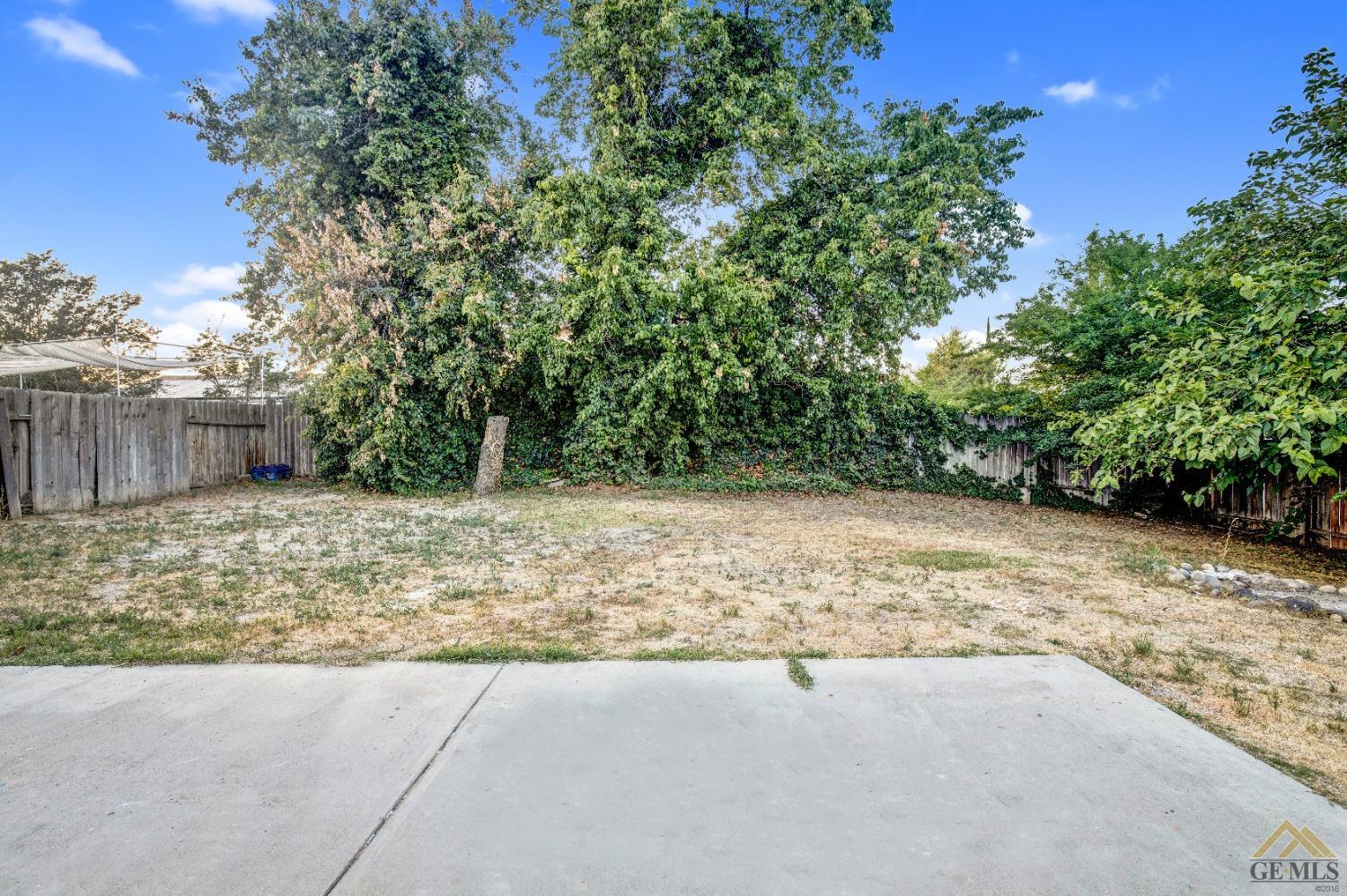 Undisclosed Address Bakersfield, CA 93304 - Photo 29 of 32 a view of backyard with large trees and wooden fence