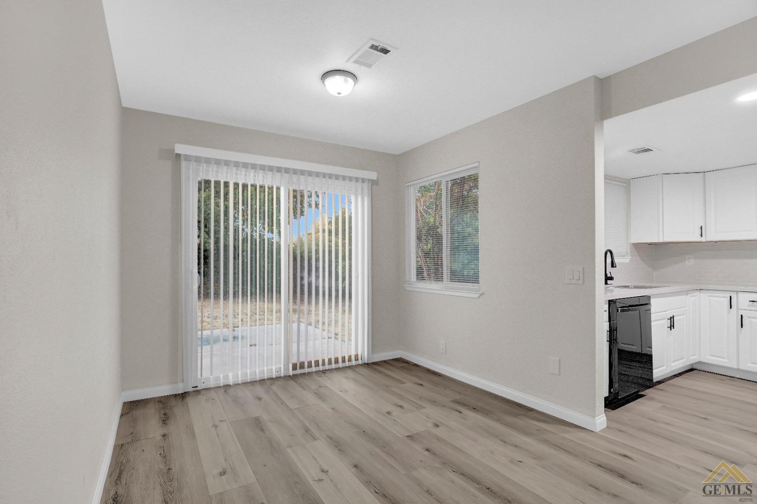 Undisclosed Address Bakersfield, CA 93304 - Photo 8 of 32 a view of a kitchen with wooden floor and a window