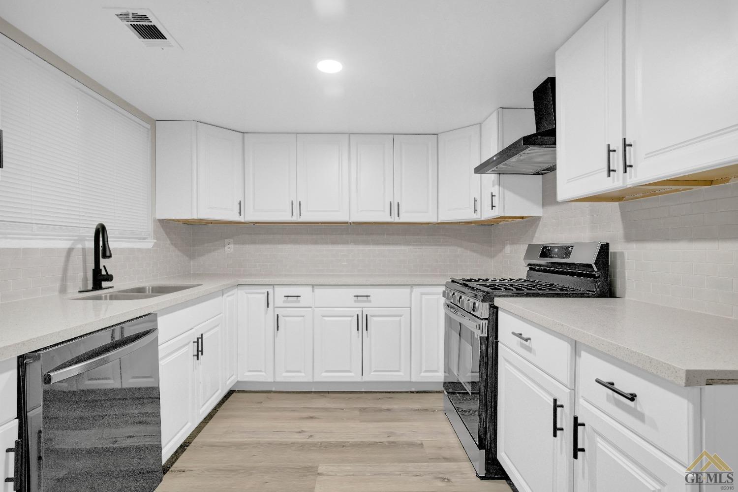 Undisclosed Address Bakersfield, CA 93304 - Photo 9 of 32 a kitchen with white cabinets and appliances