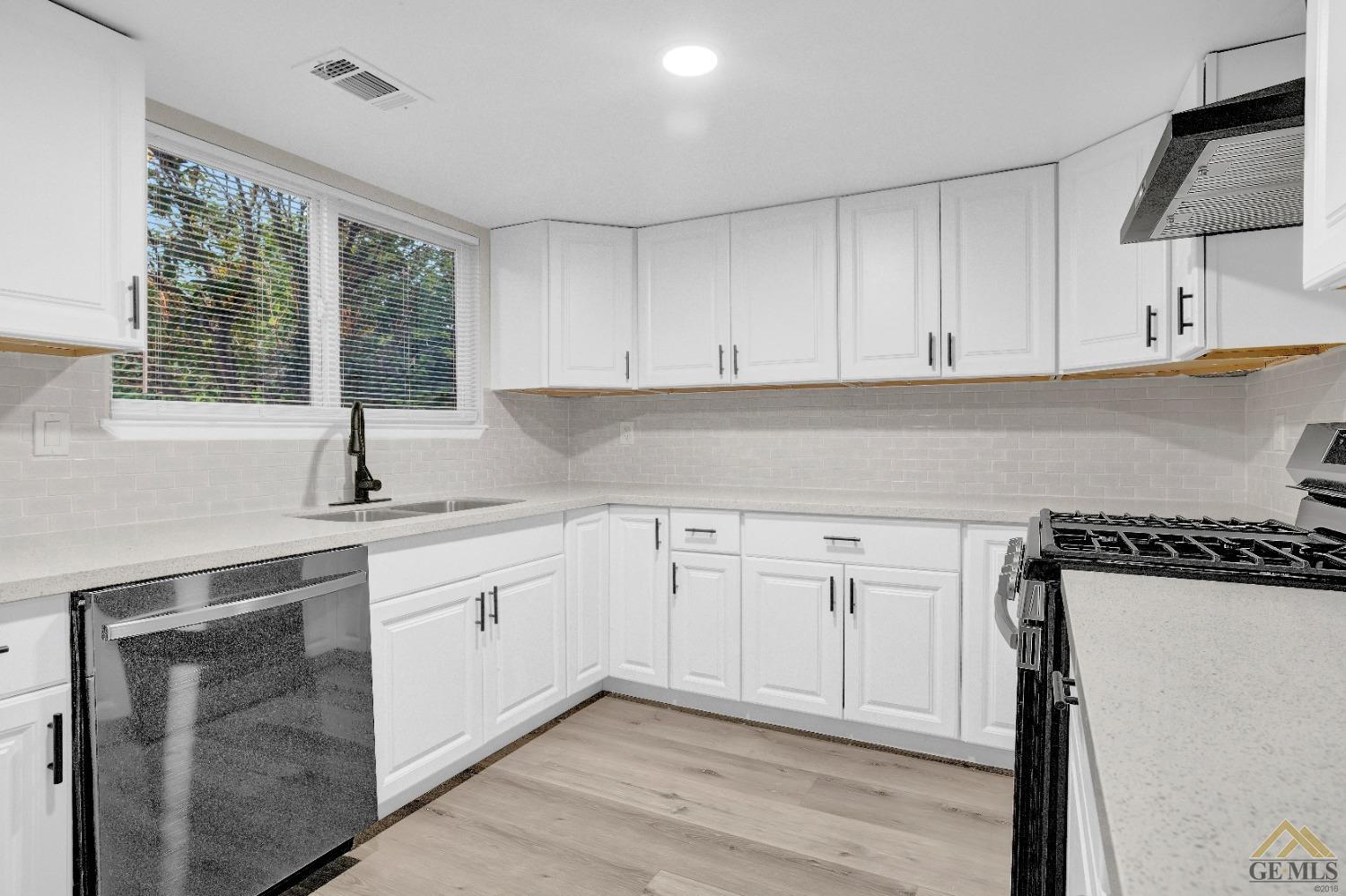 Undisclosed Address Bakersfield, CA 93304 - Photo 10 of 32 a kitchen with granite countertop white cabinets and white appliances