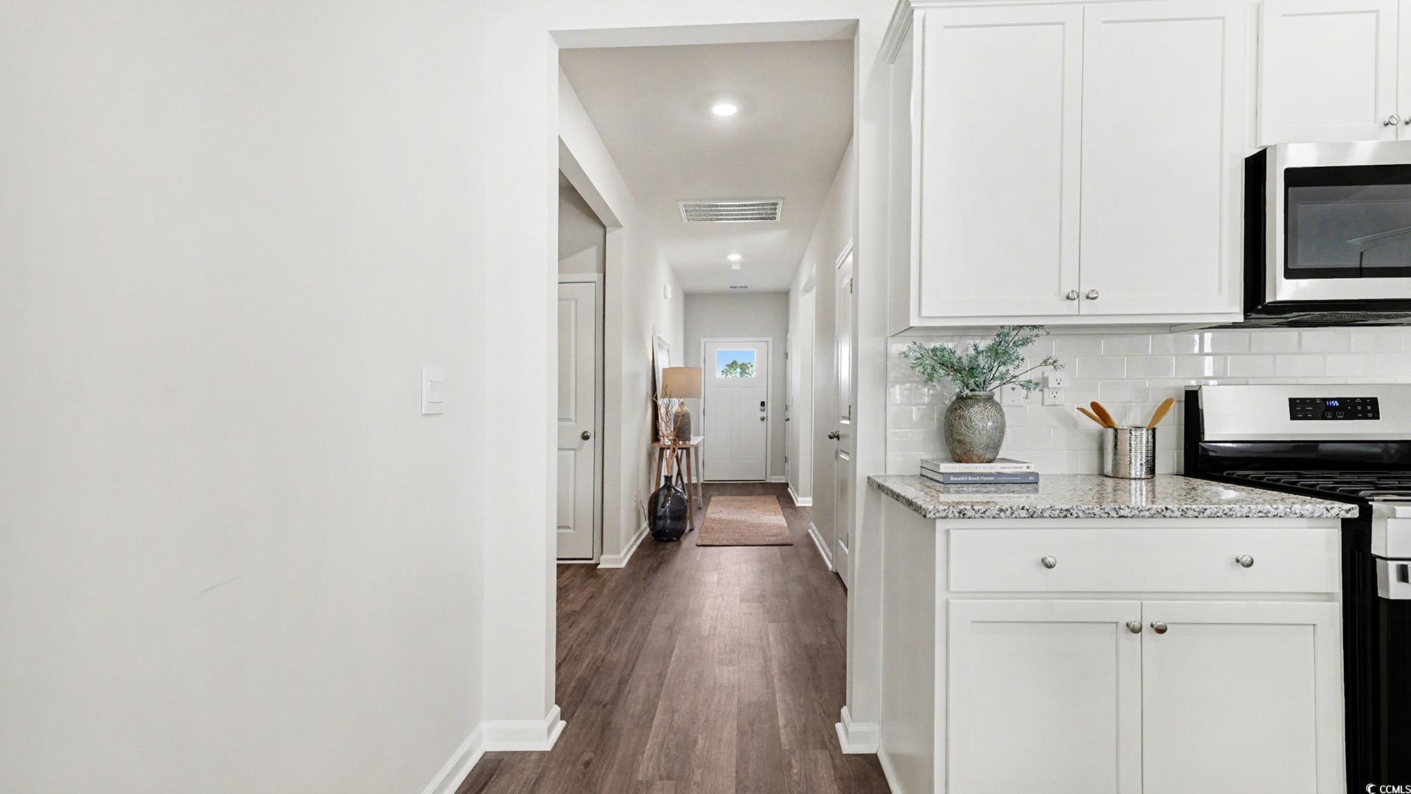 312 RookRoost Circle Conway, SC 29526 - Photo 14 of 29 Kitchen featuring appliances with stainless steel finishes, white cabinets, light stone countertops, dark wood-style floors, and recessed lighting