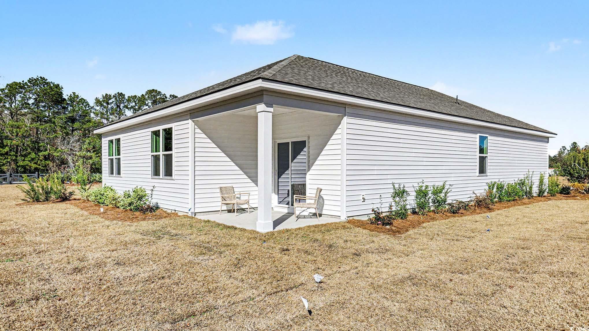 312 RookRoost Circle Conway, SC 29526 - Photo 27 of 29 Back of house with a patio area, a lawn, and roof with shingles