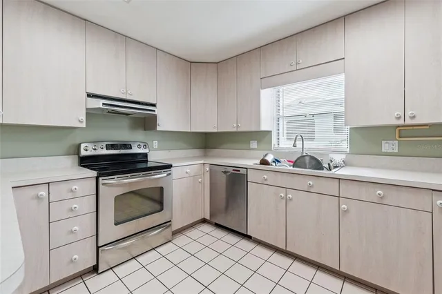a kitchen with white cabinets appliances and a sink
