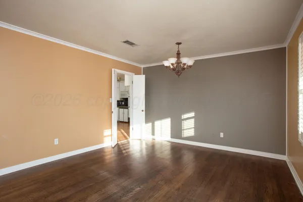 a view of an empty room with wooden floor