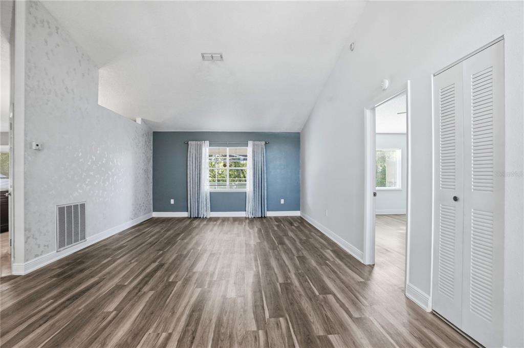 5277 Deltona Boulevard Spring Hill, FL 34606 - Photo 11 of 74 a view of an empty room with wooden floor and a window