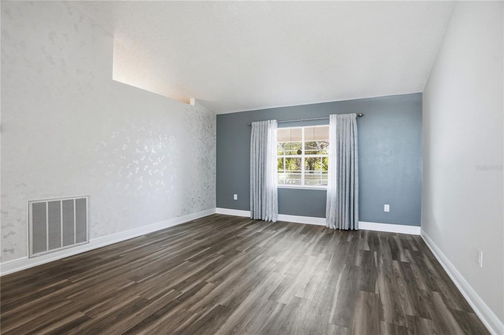 5277 Deltona Boulevard Spring Hill, FL 34606 - Photo 12 of 74 wooden floor in an empty room with a window