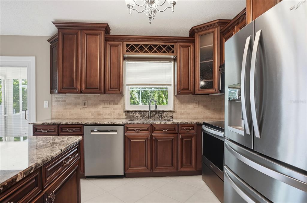 5277 Deltona Boulevard Spring Hill, FL 34606 - Photo 17 of 74 a kitchen with stainless steel appliances granite countertop a sink stove and refrigerator
