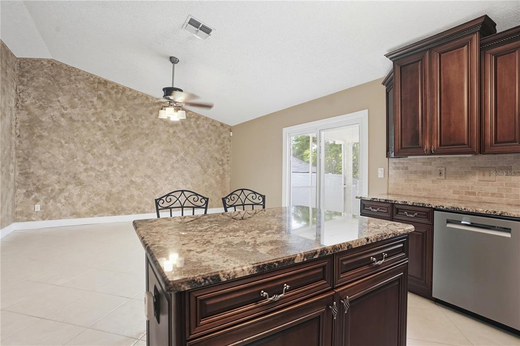 5277 Deltona Boulevard Spring Hill, FL 34606 - Photo 18 of 74 a kitchen with granite countertop a stove cabinets and window