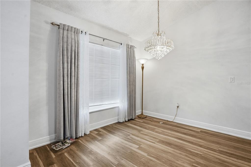 5277 Deltona Boulevard Spring Hill, FL 34606 - Photo 23 of 74 a view of a room with wooden floor and a ceiling fan