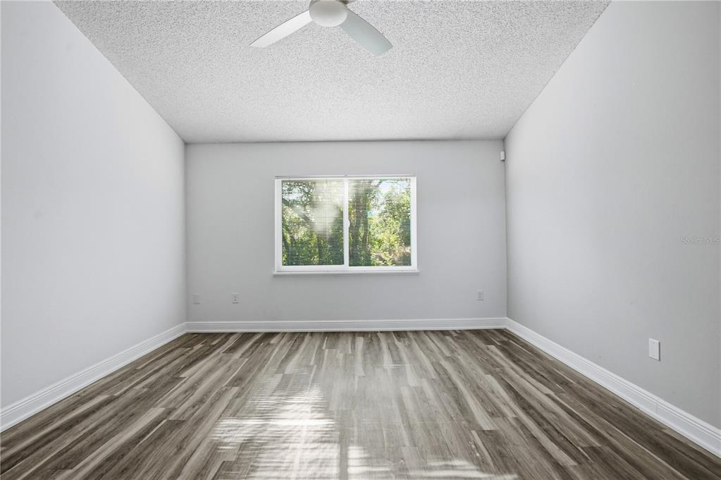 5277 Deltona Boulevard Spring Hill, FL 34606 - Photo 26 of 74 an empty room with wooden floor and windows