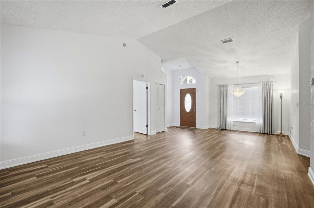 5277 Deltona Boulevard Spring Hill, FL 34606 - Photo 3 of 74 a view of an empty room with window and wooden floor