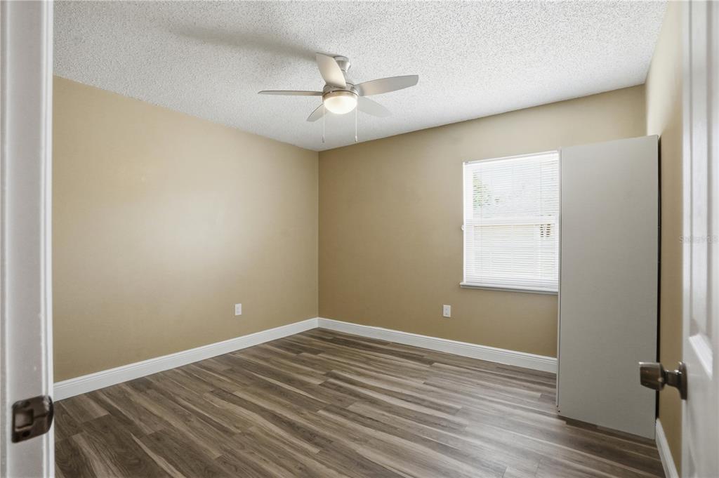 5277 Deltona Boulevard Spring Hill, FL 34606 - Photo 34 of 74 an empty room with a window and wooden floor